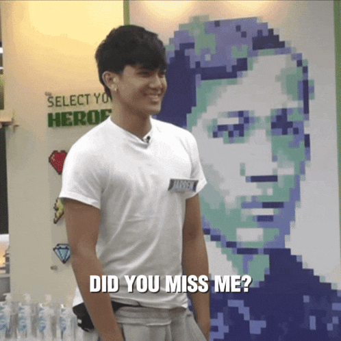 a man in a white shirt stands in front of a pixelated portrait of a man with the words did you miss me below him