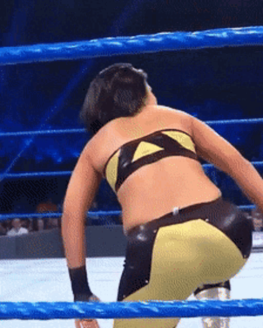 a woman in a wrestling ring with a blue rope around her