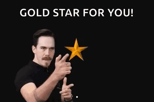 a man is pointing at two gold stars and saying `` gold star for you ! ''