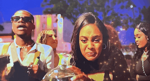 a woman is crying while a man holds a bottle
