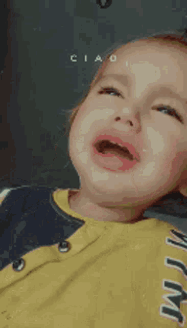 a person is making a funny face and the word ciao is on the wall