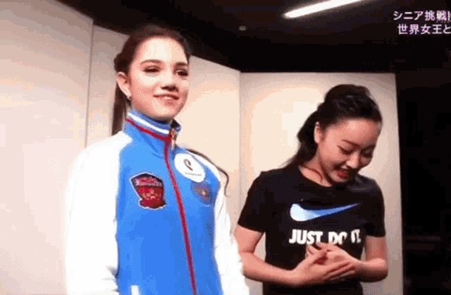 a couple of women are standing next to each other in a room .
