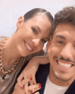 a man and a woman are posing for a picture and smiling .