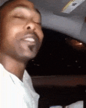 a man is sitting in a car with his eyes closed and a sun visor on the ceiling
