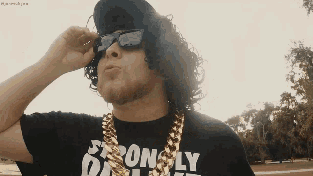 a man wearing sunglasses and a strongly daily shirt