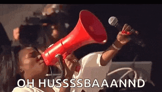 a woman is holding a red megaphone in her mouth and shouting into it .