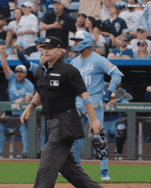 a baseball player with the number 11 on his jersey runs towards the umpire