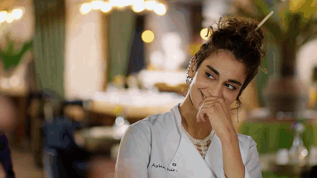 a woman wearing a white chef 's coat has aylin written on her jacket