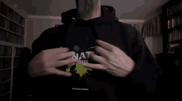 a man is wearing a hoodie that says inati token