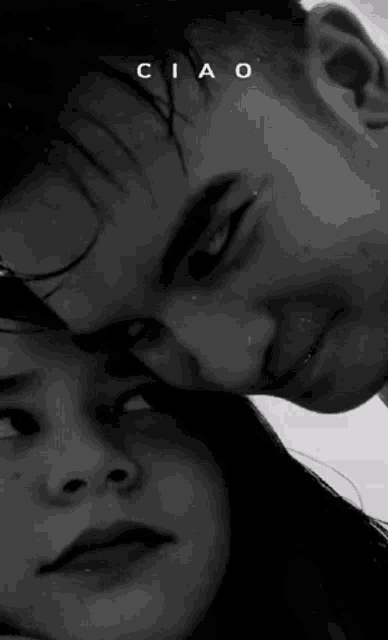 a black and white photo of a man and a woman looking at each other .