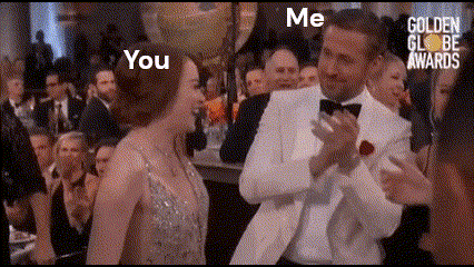 a man and a woman are standing next to each other in front of a crowd at a golden globes awards .