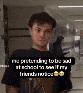 a man in a black shirt is pretending to be sad at school