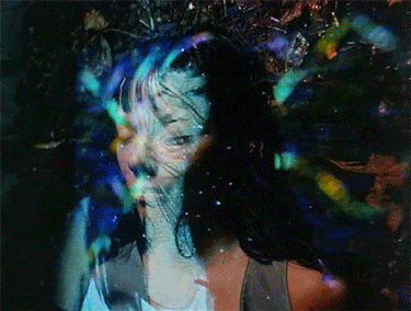 a blurry picture of a woman 's face with a purple and blue background