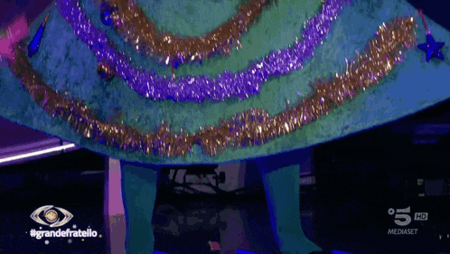 a tv screen shows a christmas tree with the words grandefratello on the bottom