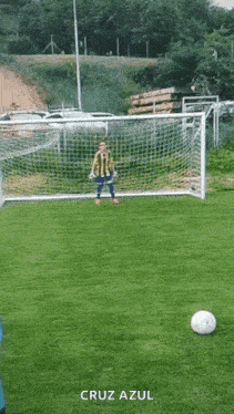 a soccer goalie stands in front of a cross azul soccer ball