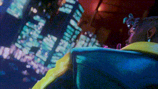 a person in a yellow jacket is looking up at a city skyline at night