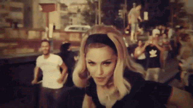 a woman wearing a headband is standing in front of a crowd