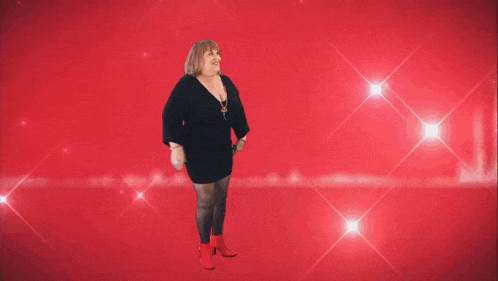a woman wearing a black top and a necklace is dancing