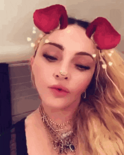 a close up of a woman wearing a nose ring and a rose headband
