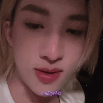 a close up of a person 's face with a pink lip and a nose ring .