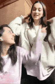 a couple of girls are standing next to each other