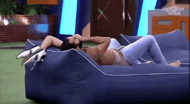 a man is laying on a bean bag chair with his head in his hands .