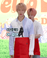 a man in a white shirt with a dog on it is standing next to another man in a red skirt ..