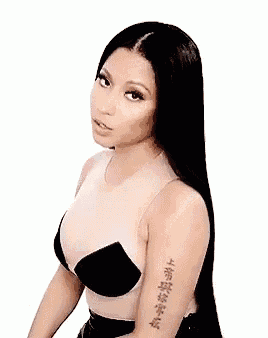 a woman with long black hair and a tattoo on her arm is looking at the camera .