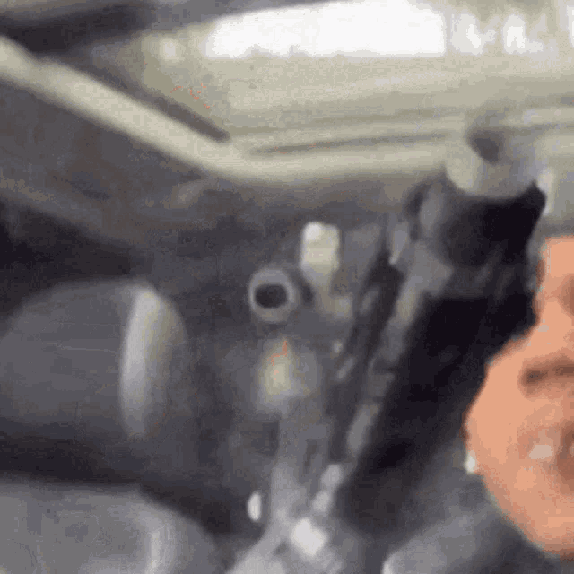 a person is holding a gun in their hand while sitting in a car .