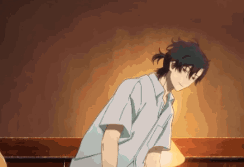 a man in a blue shirt is standing in front of a lamp