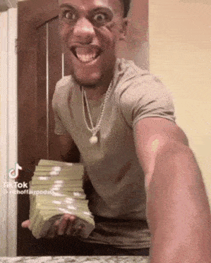 a man is holding a large stack of money in his hands .
