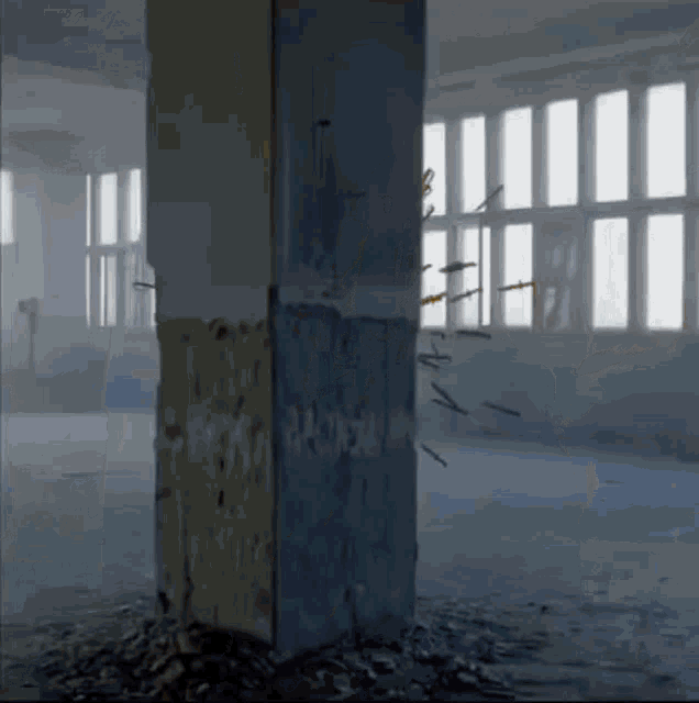 an empty room with a pillar and a bunch of bullets in it
