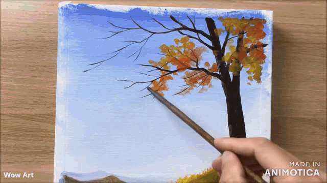 a person is painting a tree with a brush on a piece of paper that says wow art
