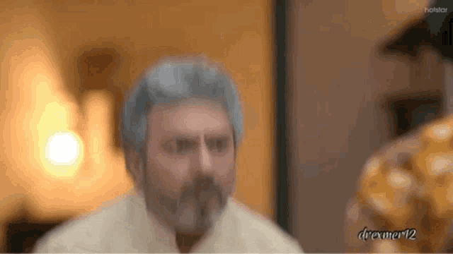 a blurred image of a man with a beard and gray hair