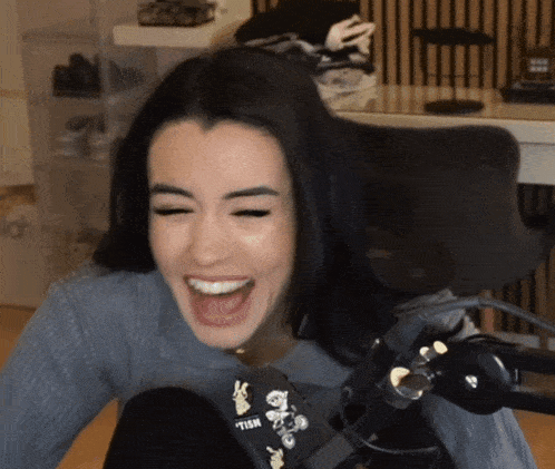 a woman is laughing in front of a microphone that says ' tsm ' on it