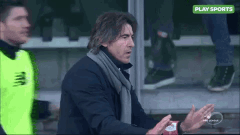 a man with a scarf around his neck is talking to another man in a play sports advertisement