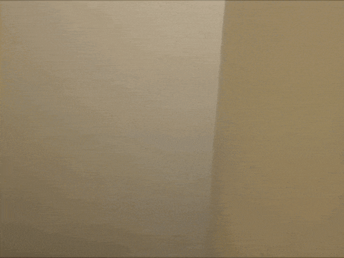 a woman with a horn on her head is peeking behind a wall