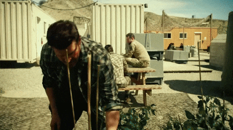 a man in a plaid shirt is drinking water from a straw