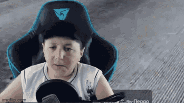 a young boy is sitting in a gaming chair with a microphone and a hat on .