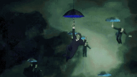 a man in a suit is flying through the air holding an umbrella .