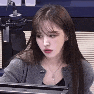 a woman is sitting in front of a microphone .