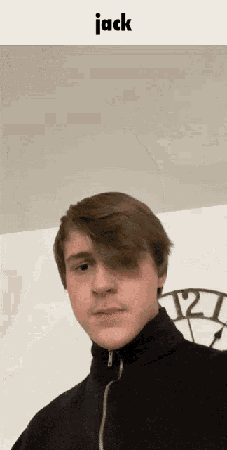 a young man is standing in front of a clock with the name jack above him