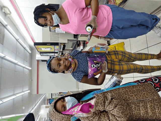 a woman holding a bag of doritos next to another woman
