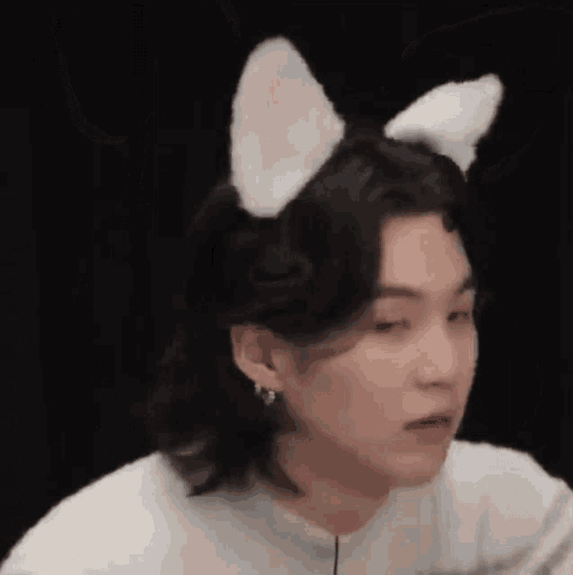 a close up of a person wearing cat ears and earrings .
