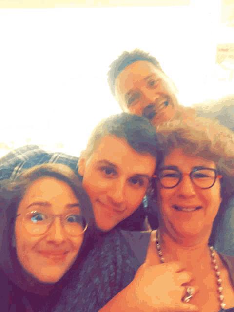 a group of people posing for a picture including a woman with glasses