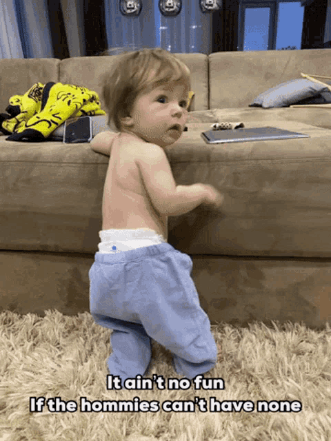 a baby is standing in front of a couch with the words it ain t no fun