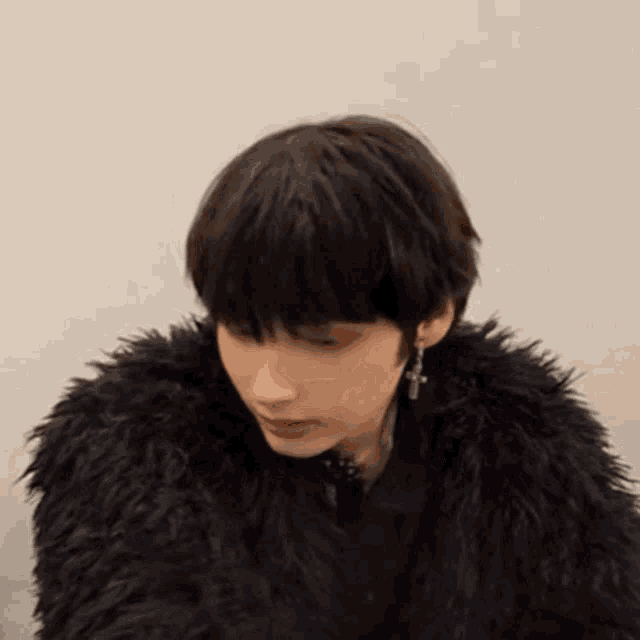 a close up of a person wearing a black fur coat .