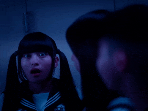 a girl with pigtails is looking at herself in the mirror