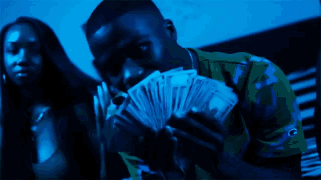 a man is holding a bunch of money in his hands