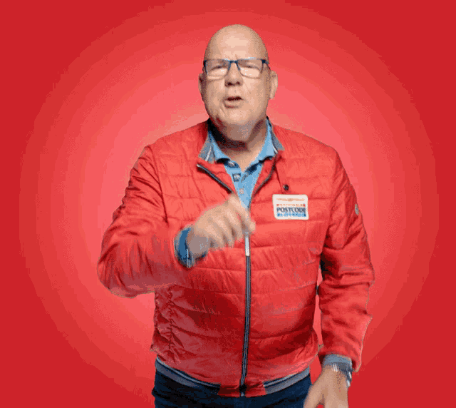 a bald man wearing a red jacket with a name tag that says antonio